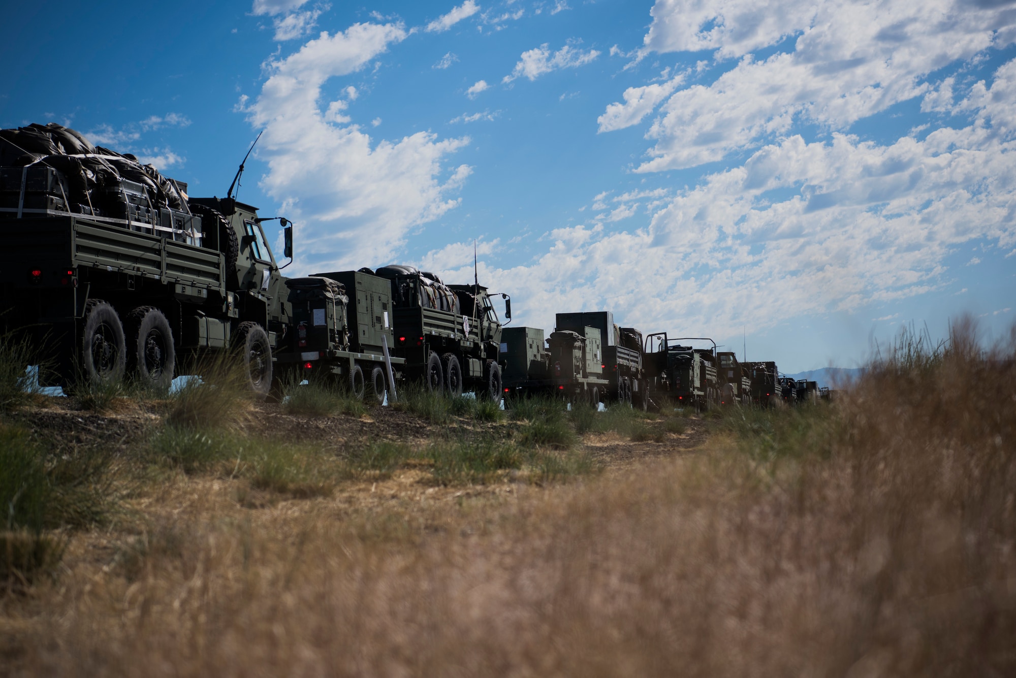 A U.S. Air Force convoy of 5-ton trucks from the 726th Air Control Squadron transports a variety of equipment July 14, 2019, near Mountain Home Air Force Base, Idaho. This convoy was in support of Hardrock Exercise 19-2, where supplies on the truck enabled the 726th ACS Airmen to set up an entirely self-sufficient base in a simulated remote location. (U.S. Air Force photo by Airman 1st Class Andrew Kobialka)