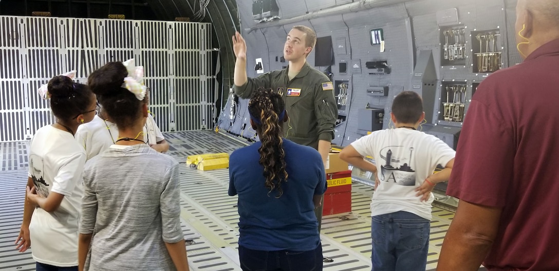 Tech. Sgt. Joshua Green, 356th Airlift Squadron loadmaster, describes the C-5M Super Galaxy’s cargo compartment to students with the San Antonio Chapter of Tuskegee Airmen Inc.’s Youth Science, Technology, Engineering and Mathematics-Aviation Program July 12, 2019 at Joint Base San Antonio-Lackland, Texas.