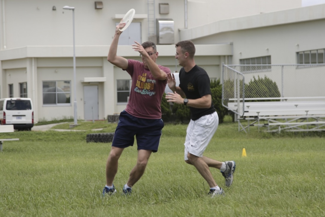 U.S. Marine Corps Staff Sgt. Kevin Willis (left) and Sgt. Dalton Lewis (right), both Marines with III Marine Expeditionary Force Band, compete during the Camp Foster Ultimate Frisbee Tournament at Camp Foster, Okinawa, Japan July 14, 2019.