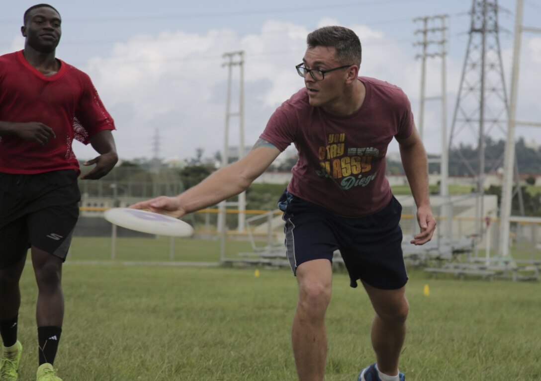U.S. Marine Corps Staff Sgt. Kevin Willis (left) and Sgt. Dalton Lewis (right), both Marines with III Marine Expeditionary Force Band, compete during the Camp Foster Ultimate Frisbee Tournament at Camp Foster, Okinawa, Japan July 14, 2019.