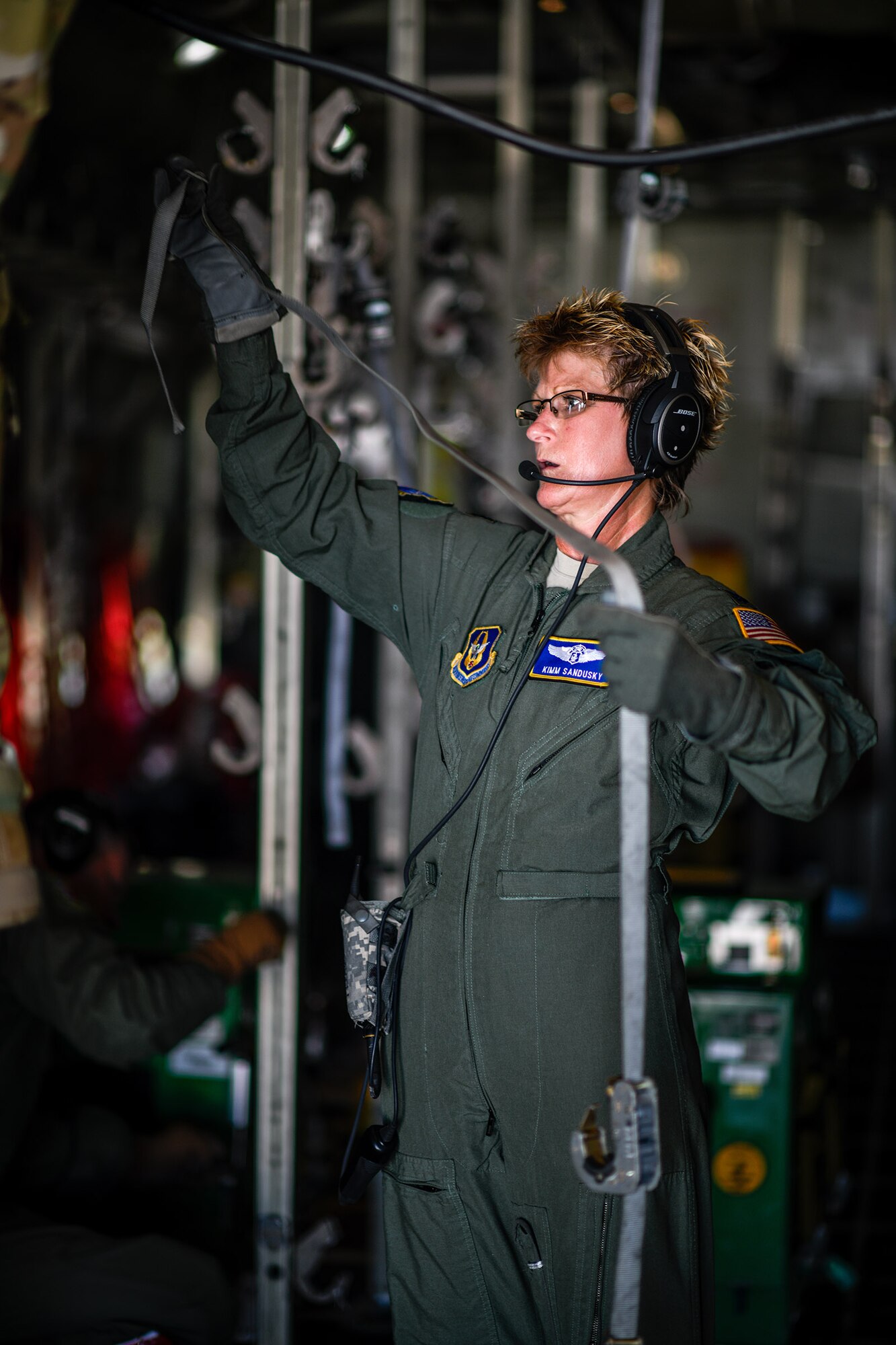 U.S. Air Force Lt. Col. Kimm Sandusky, a reserve Airman with the 445th Aeromedical Evacuation Squadron, extends cargo straps aboard a Youngstown Air Reserve Station C-130H Hercules on the flight line at Wright-Patterson Air Force Base, Ohio, July 10, 2019. YARS personnel flew to Wright-Patterson AFB to assist in an aeromedical evacuation training sortie. (U.S. Air Force photo by Senior Airman Christina Russo)