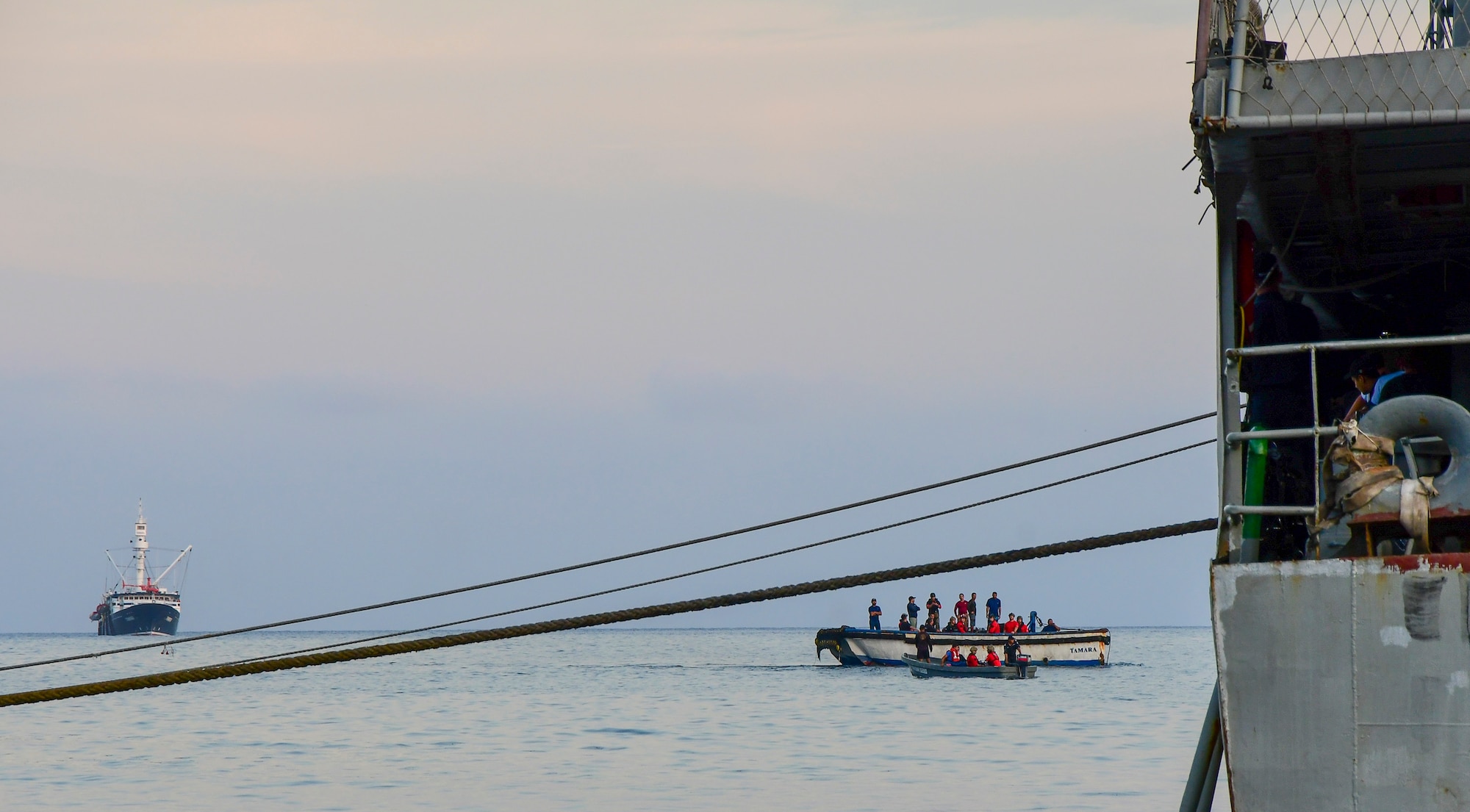 Pararescuemen from the 48th Rescue Squadron, Davis-Monthan Air Force Base, Arizona, along with injured fishermen are transported from the Tamara, a fishing vessel, to Socorro Island, Mexico, July 14, 2019. The pararescuemen cared for fishermen, who were injured when a 25-ton crane fell on them. A Travis AFB, California, KC-10 Extender refueled the HC-130J over the Pacific Ocean enabling it to make it to the Tamara. (U.S. Air Force photo by Airman 1st Class Kristine Legate)