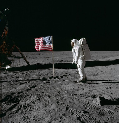 Astronaut Edwin E. Aldrin Jr., lunar module pilot of the first lunar landing mission, poses for a photograph beside the deployed United States flag during an Apollo 11 extravehicular activity (EVA) on the lunar surface. The Lunar Module (LM) is on the left, and the footprints of the astronauts are clearly visible in the soil of the moon. Astronaut Neil A. Armstrong, commander, took this picture with a 70mm Hasselblad lunar surface camera. While astronauts Armstrong and Aldrin descended in the LM, the "Eagle", to explore the Sea of Tranquility region of the moon, astronaut Michael Collins, command module pilot, remained with the Command and Service Modules (CSM) "Columbia" in lunar orbit. Photo credit: NASA