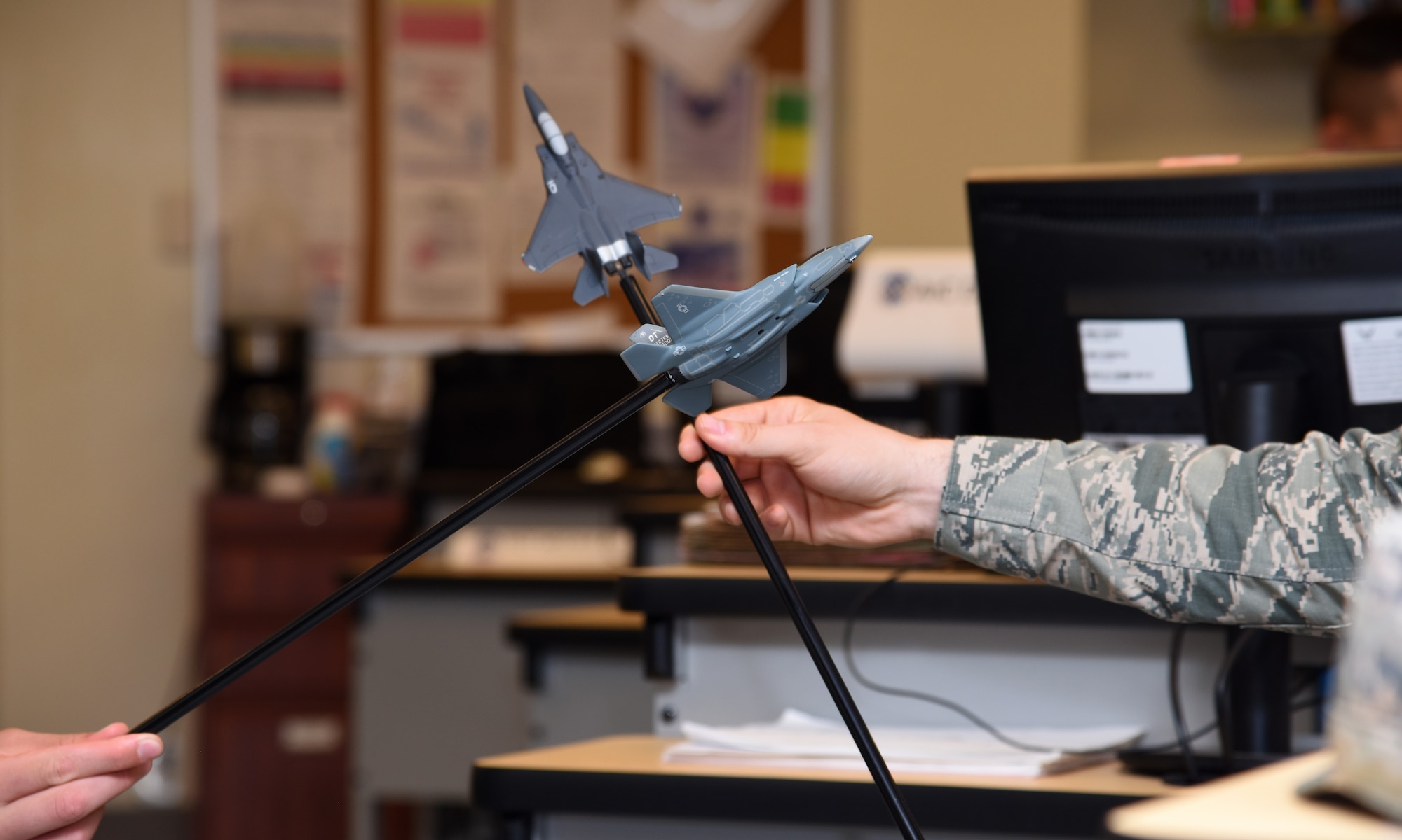 U.S. Air Force students maneuver aircraft props and talk through what-if scenarios during their weapons block in their All Source Intelligence Analyst course in Di Tommaso Hall on Goodfellow Air Force Base, Texas, July 10, 2019. The All Source Intelligence Analyst course teaches students over a 13-block period how to receive, analyze, report and disseminate information for key elements to ensure missions are completed safely and successfully. (U.S. Air Force photo by Airman 1st Class Abbey Rieves/Released)