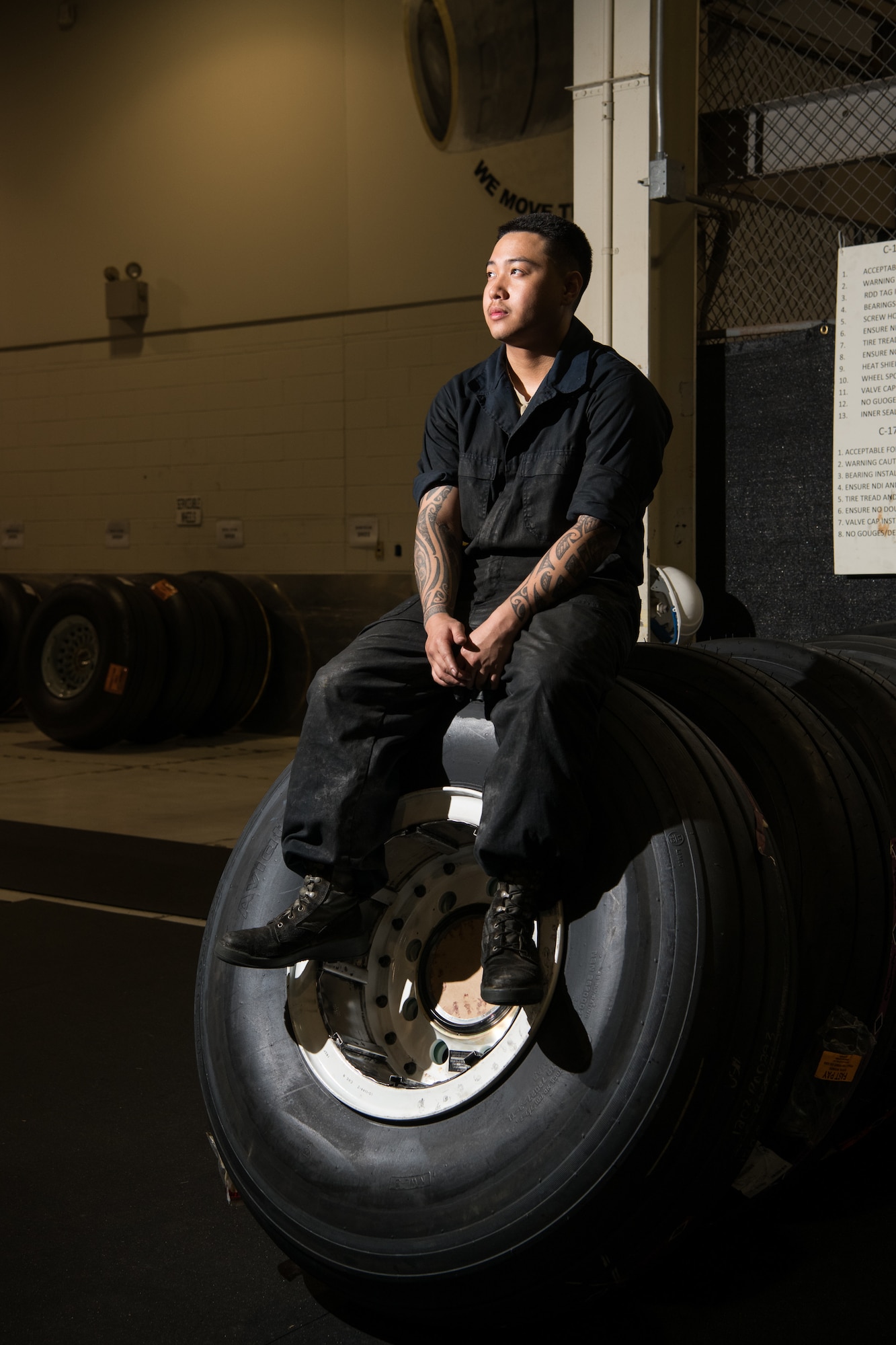 Airman Bryan Peredo, 436th Maintenance Squadron wheel and tire journeyman, sits atop an aircraft tire June 13, 2019, at Dover Air Force Base, Del. In 2018, the 436th MXS wheel and tire section replaced and maintained 538 tires from the C-17 Globemaster III and the C-5 Galaxy aircraft at Dover AFB. (U.S. Air Force photo by Mauricio Campino)