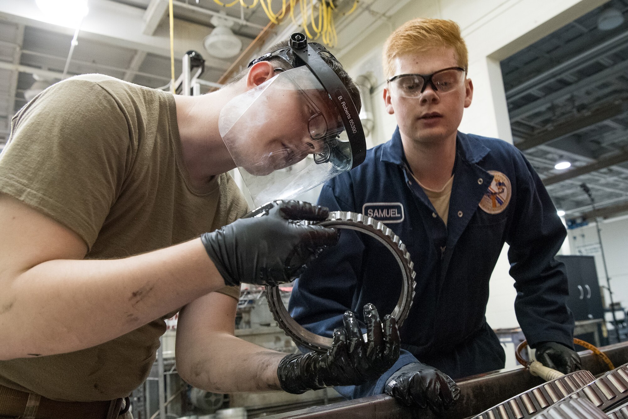 Senior Airman Tyler Bobbitt and Airman 1st Class Samuel Rutledge, both 436th Maintenance Squadron wheel and tire journeymen, clean and inspect aircraft wheel bearings June 13, 2019, at Dover Air Force Base, Del. The bearings must be routinely degreased and inspected for corrosion before reinstallation. (U.S. Air Force photo by Mauricio Campino)