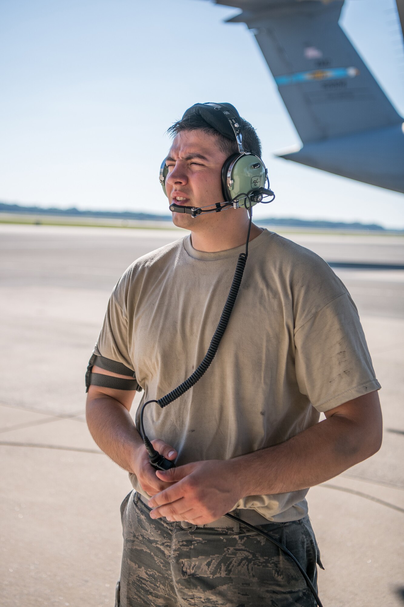 Senior Airman Thunderiel Cardoza, 436th Maintenance Squadron C-17 aircraft hydraulics journeyman, communicates with a fellow airman through his radio headset June 27, 2019, at Dover Air Force Base, Del. Airmen simultaneously performing maintenance tasks in various parts of the aircraft must maintain constant  communication with each other via radio. (U.S. Air Force photo by Mauricio Campino)