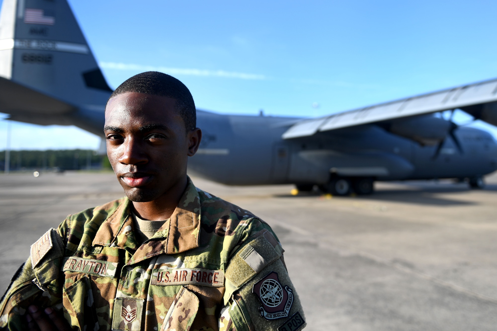 A man stands in front of a C-130J.