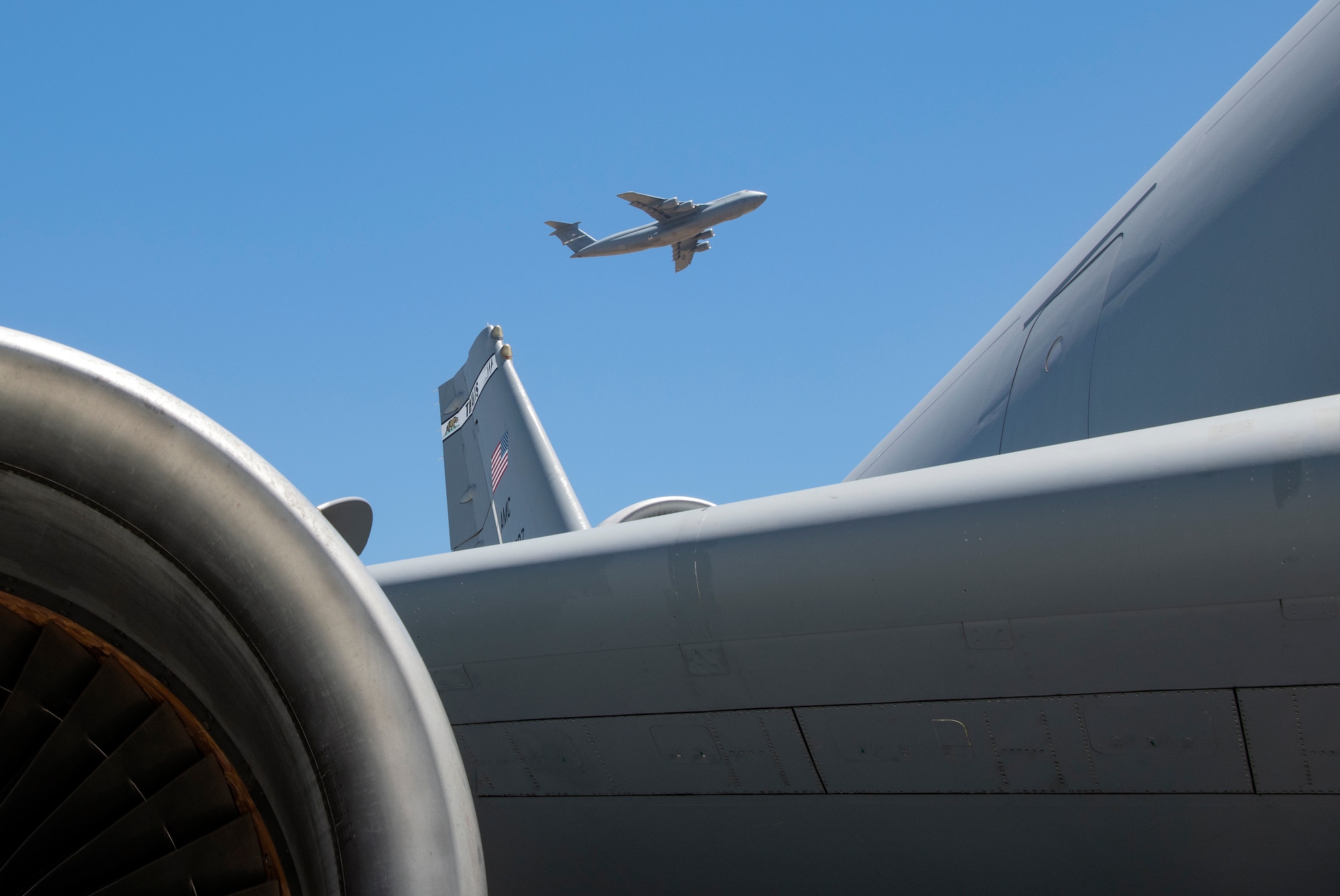 A KC-10 Extender is seen in the foreground of a departing C-5M Super Galaxy July 11, 2019, at Travis Air Force Base, California. With roughly 3,300 aircraft continuously arriving and departing on a monthly basis, Travis handles more cargo and passenger traffic than any other military air terminal in the United States. (U.S. Air Force photo by Heide Couch)