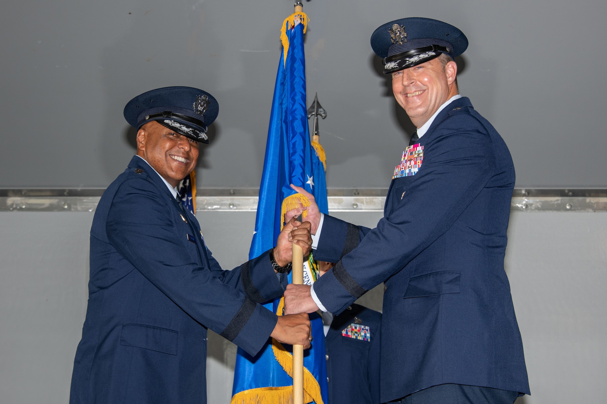 Lieutenant Gen. Anthony Cotton, Air University commander, presents the unit flag for the Curtis E. LeMay Center for Doctrine Development and Education to Maj. Gen. Brad Sullivan, who took command of the center on July 15, 2019, at a change of command ceremony on Maxwell Air Force Base, Alabama. In his position as the LeMay Center commander, Sullivan also serves as the vice commander of Air University.