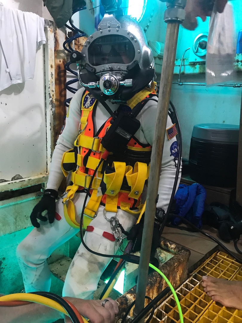 David Coan, extra vehicular activity lead for the National Aeronautics and Space Administration (NASA) Johnson Space Center prepares for a dive donning a Kirby Morgan-37 helmet equipped with the Divers Augmented Vision Device Generation 1.0 heads-up display during the 23rd NASA Extreme Environment Mission Operations in June 2019 at the Aquarius Reef Base underwater habitat.