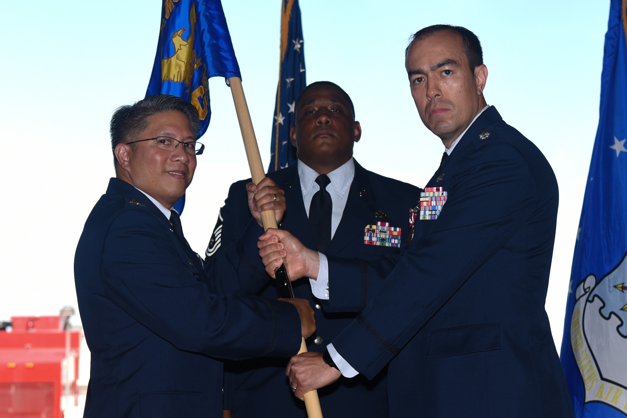 Lt. Col. Daniel Craig, the outgoing 22nd Civil Engineering Squadron commander, passes Col. Anthony Gamboa, 22nd Mission Support Group commander, the 22nd CES guidon during a change of command ceremony July 16, 2019, at McConnell Air Force Base, Kan. Craig served as the 22nd CES commander for two years before relinquishing command. (U.S. Air Force photo by Airman 1st Class Alexi Myrick)