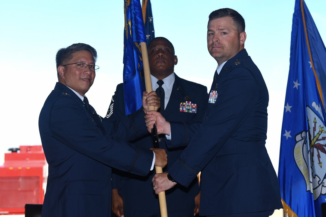 Col. Anthony Gamboa, 22nd Mission Support Group commander, passes the 22nd Civil Engineering Squadron guidon to Lt. Col. Jacob Leck, the incoming 22nd CES commander, during a change of command ceremony July 16, 2019, at McConnell Air Force Base, Kan. The passing of the guidon symbolized Leck’s acceptance of his new role as the 22nd CES commander. (U.S. Air Force photo by Airman 1st Class Alexi Myrick)