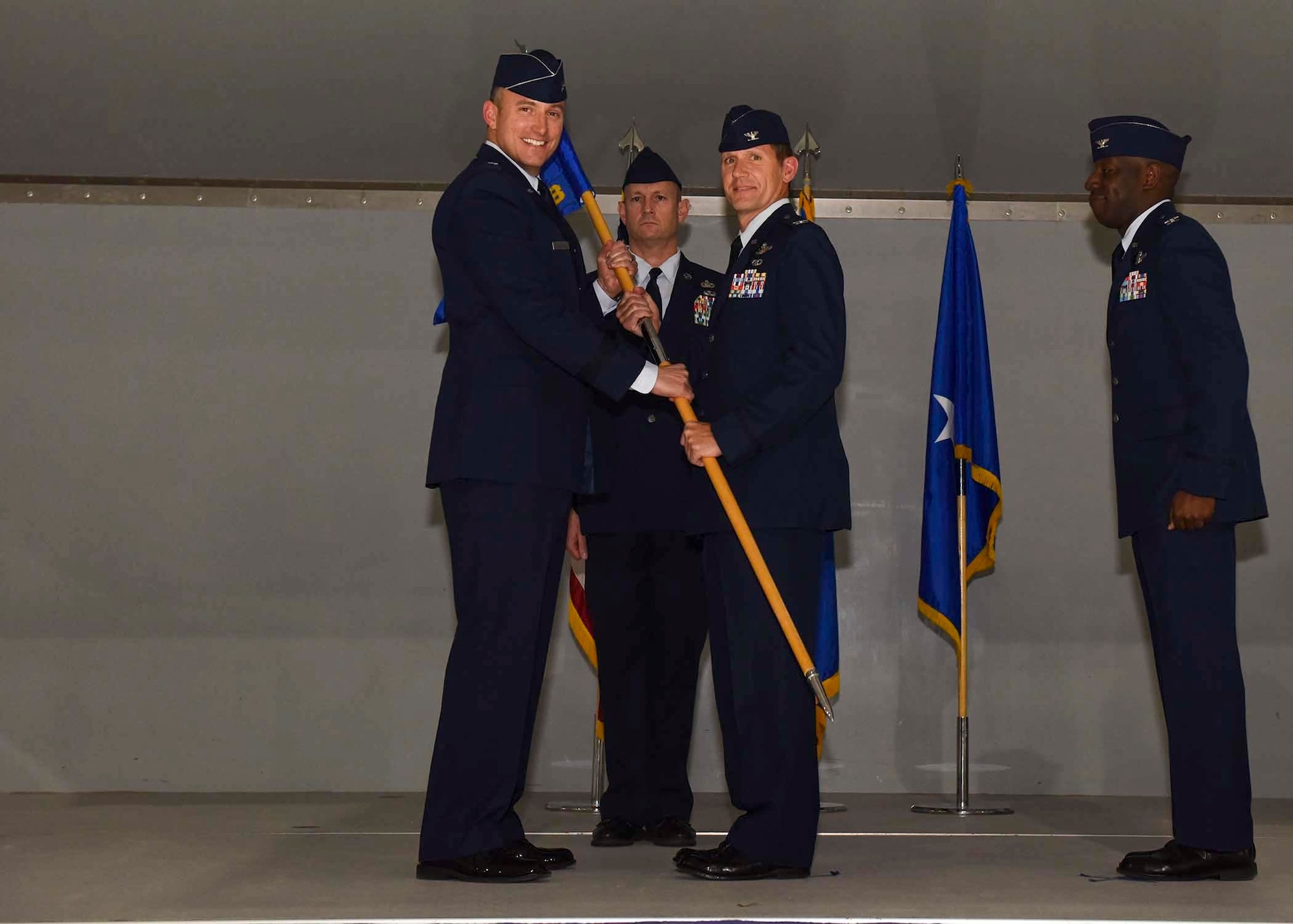 The 57th Wing commander passes the guide on to the new 57th Adversary Tactics Group commander.