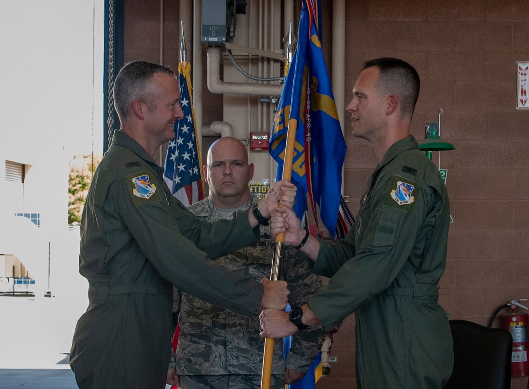 Col. R. Ryan Messer, 53rd Wing commander, Eglin Air Force Base, Florida, passes the 53rd WG guidon to Col. William Creeden, 53rd Test and Evaluation Group incoming commander, during a change of command ceremony at Nellis AFB, Jul. 10, 2019. Creeden is a command pilot with over 1500 hours in the F-22 Raptor fighter jet and the F-15C Eagle fighter jet, and has served in five different squadrons, three fighter wings, and at the MAJCOM level. (U.S. Air Force photo by Airman 1st Class Dwane R. Young)