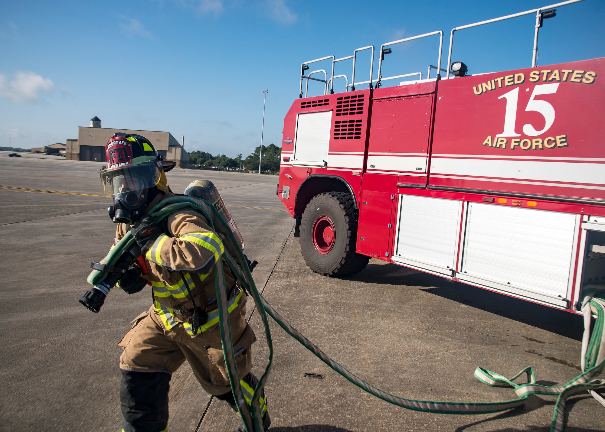 A firefighter from the 23d Civil Engineer Squadron (CES), pulls a hose during HC-130J Combat King II egress training, July 11, 2019, at Moody Air Force Base, Ga. Firefighters conducted the training to evaluate their overall knowledge and proficiency of how to properly shut down and rescue personnel from a C-130 during an emergency situation. (U.S. Air Force photo by Airman 1st Class Eugene Oliver)