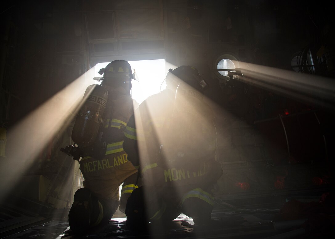 Staff Sgt. Tyler McFarland, left, and Staff Sgt. Matthew Montville, both 23d Civil Engineer Squadron (CES) firefighter crew chiefs, discuss strategy during an HC-130J Combat King II egress training, July 11, 2019, at Moody Air Force Base, Ga Firefighters conducted the training to evaluate their overall knowledge and proficiency of how to properly shut down and rescue personnel from a C-130 during an emergency situation. The training required the firefighters to properly enter and ventilate the aircraft while conducting swift rescue techniques to safely locate and remove passengers from the aircraft. (U.S. Air Force photo by Airman 1st Class Eugene Oliver)