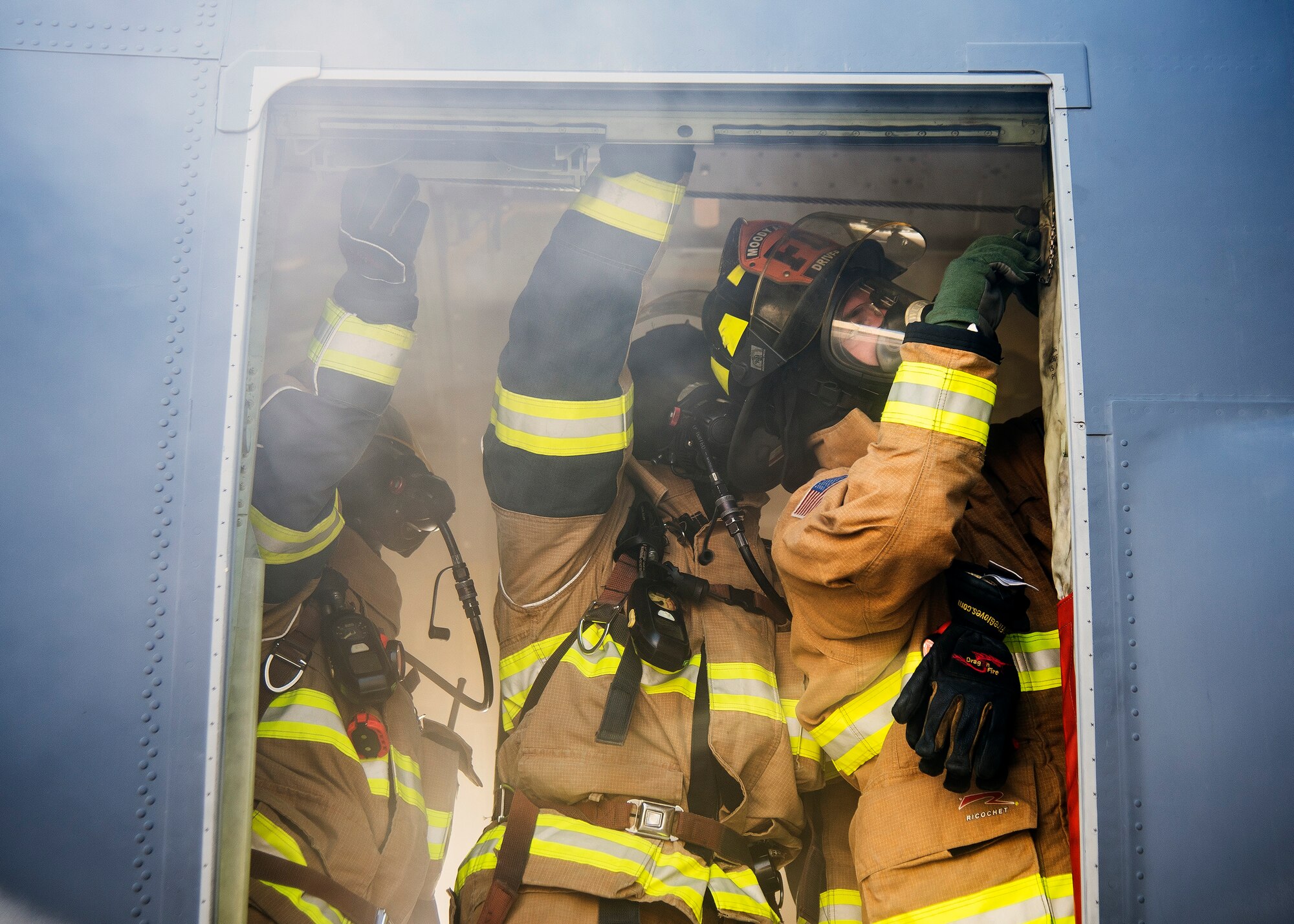 Firefighters from the 23d Civil Engineer Squadron (CES), secures a door on the side of an HC-130J Combat King II during egress training, July 11, 2019, at Moody Air Force Base, Ga. Firefighters conducted the training to evaluate their overall knowledge and proficiency of how to properly shut down and rescue personnel from a C-130 during an emergency situation. The training required the firefighters to properly enter and ventilate the aircraft while conducting swift rescue techniques to safely locate and remove passengers from the aircraft. (U.S. Air Force photo by Airman 1st Class Eugene Oliver)