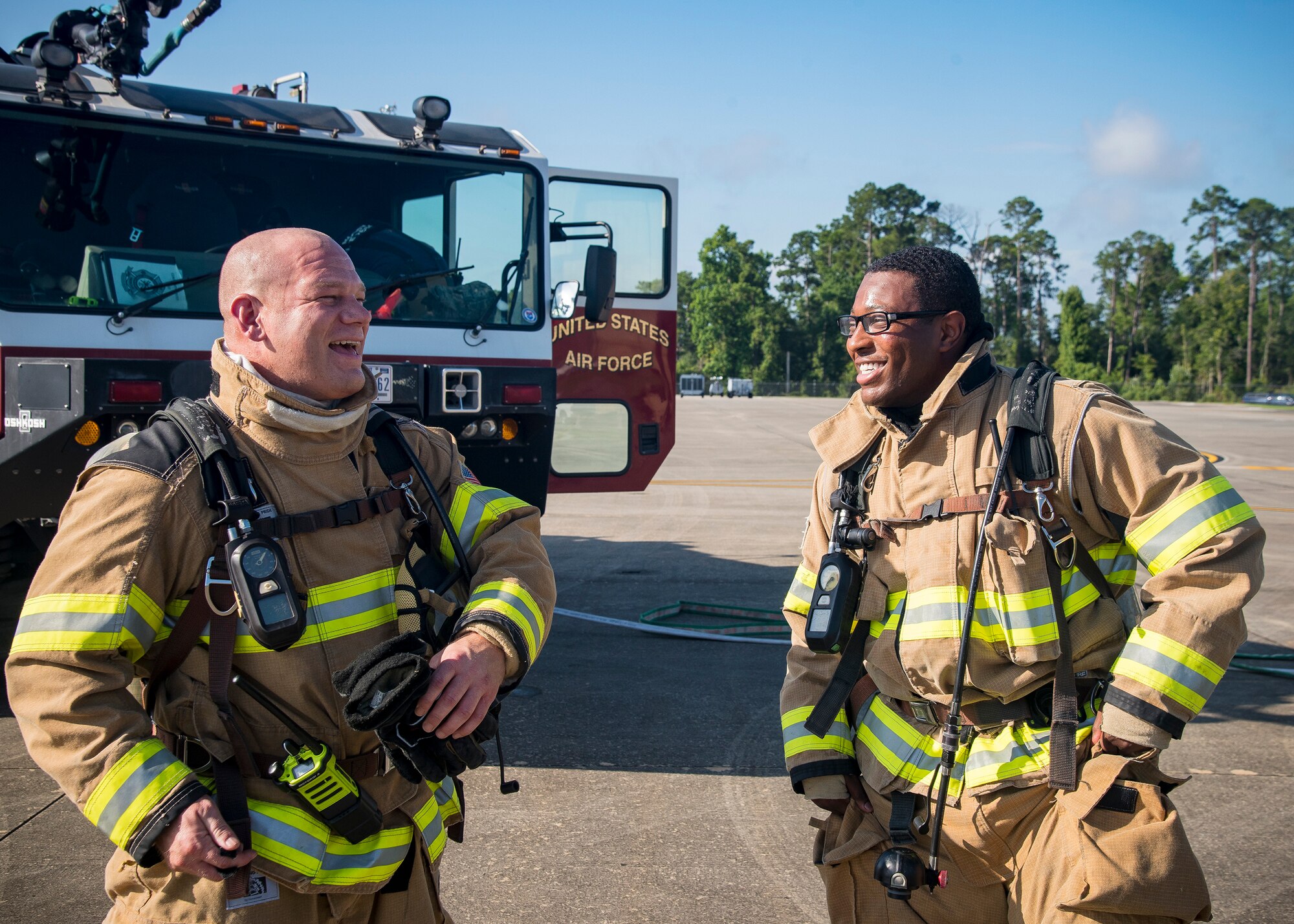 Tech Sgt Gary Schmidt, left, 23d Civil Engineer Squadron (CES) firefighter station chief and Staff Sgt. Tyler McFarland, 23d CES firefighter crew chief, share a laugh following HC-130J Combat King II egress training, July 11, 2019, at Moody Air Force Base, Ga Firefighters conducted the training to evaluate their overall knowledge and proficiency of how to properly shut down and rescue personnel from a C-130 during an emergency situation. The training required the firefighters to properly enter and ventilate the aircraft while conducting swift rescue techniques to safely locate and remove passengers from the aircraft. (U.S. Air Force photo by Airman 1st Class Eugene Oliver)