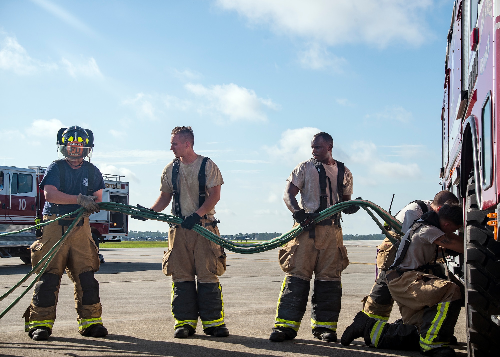 Firefighters from the 23d Civil Engineer Squadron (CES), put up a hose following HC-130J Combat King II egress training, July 11, 2019, at Moody Air Force Base, Ga. Firefighters conducted the training to evaluate their overall knowledge and proficiency of how to properly shut down and rescue personnel from a C-130 during an emergency situation. The training required the firefighters to properly enter and ventilate the aircraft while conducting swift rescue techniques to safely locate and remove passengers from the aircraft. (U.S. Air Force photo by Airman 1st Class Eugene Oliver)