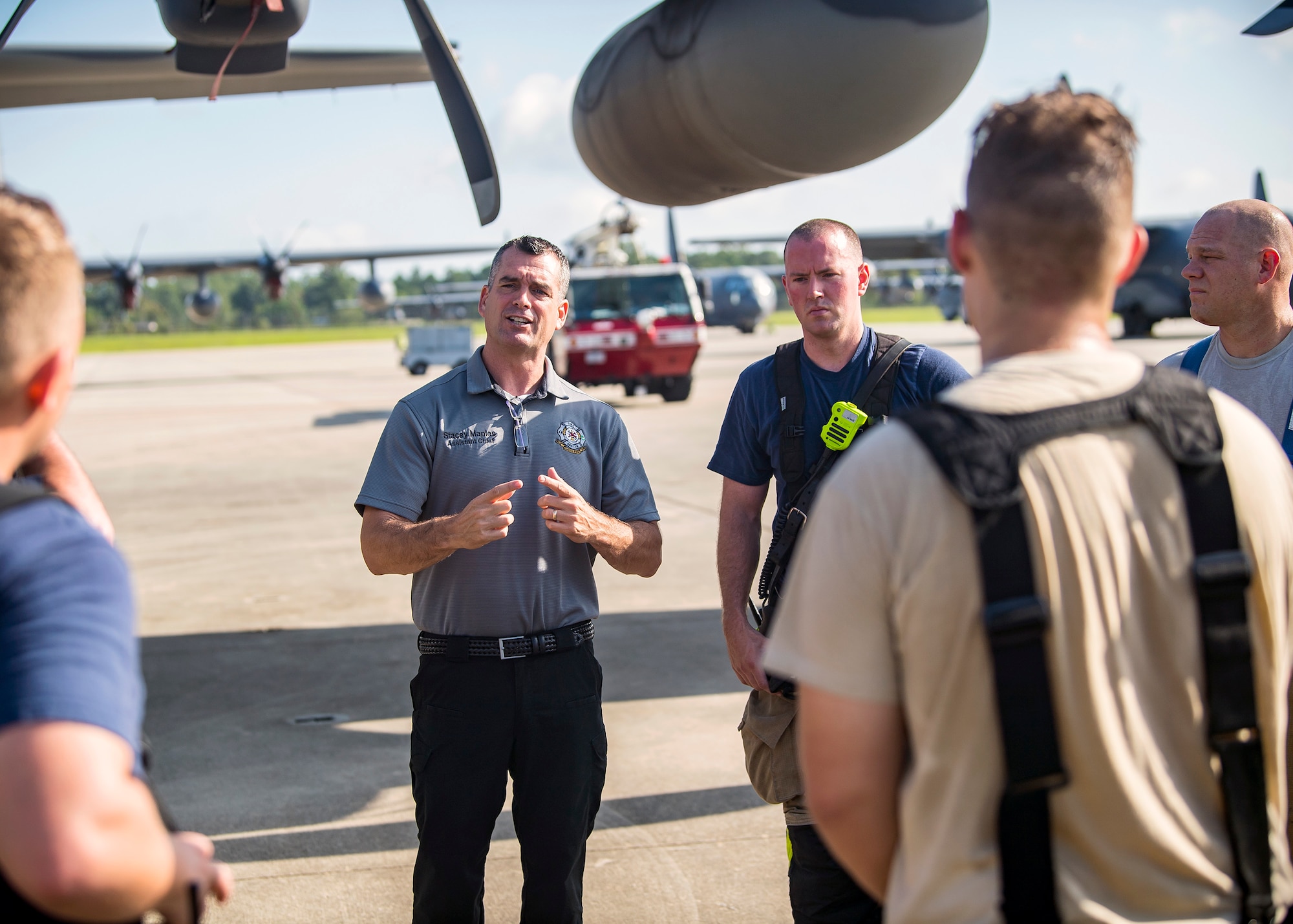 Stacey Maples, center, 23d Civil Engineer Squadron (CES) assistant fire chief, discusses the performance of the firefighters from the 23d CES following HC-130J Combat King II egress training, July 11, 2019, at Moody Air Force Base, Ga. Firefighters conducted the training to evaluate their overall knowledge and proficiency of how to properly shut down and rescue personnel from a C-130 during an emergency situation. The training required the firefighters to properly enter and ventilate the aircraft while conducting swift rescue techniques to safely locate and remove passengers from the aircraft. (U.S. Air Force photo by Airman 1st Class Eugene Oliver)