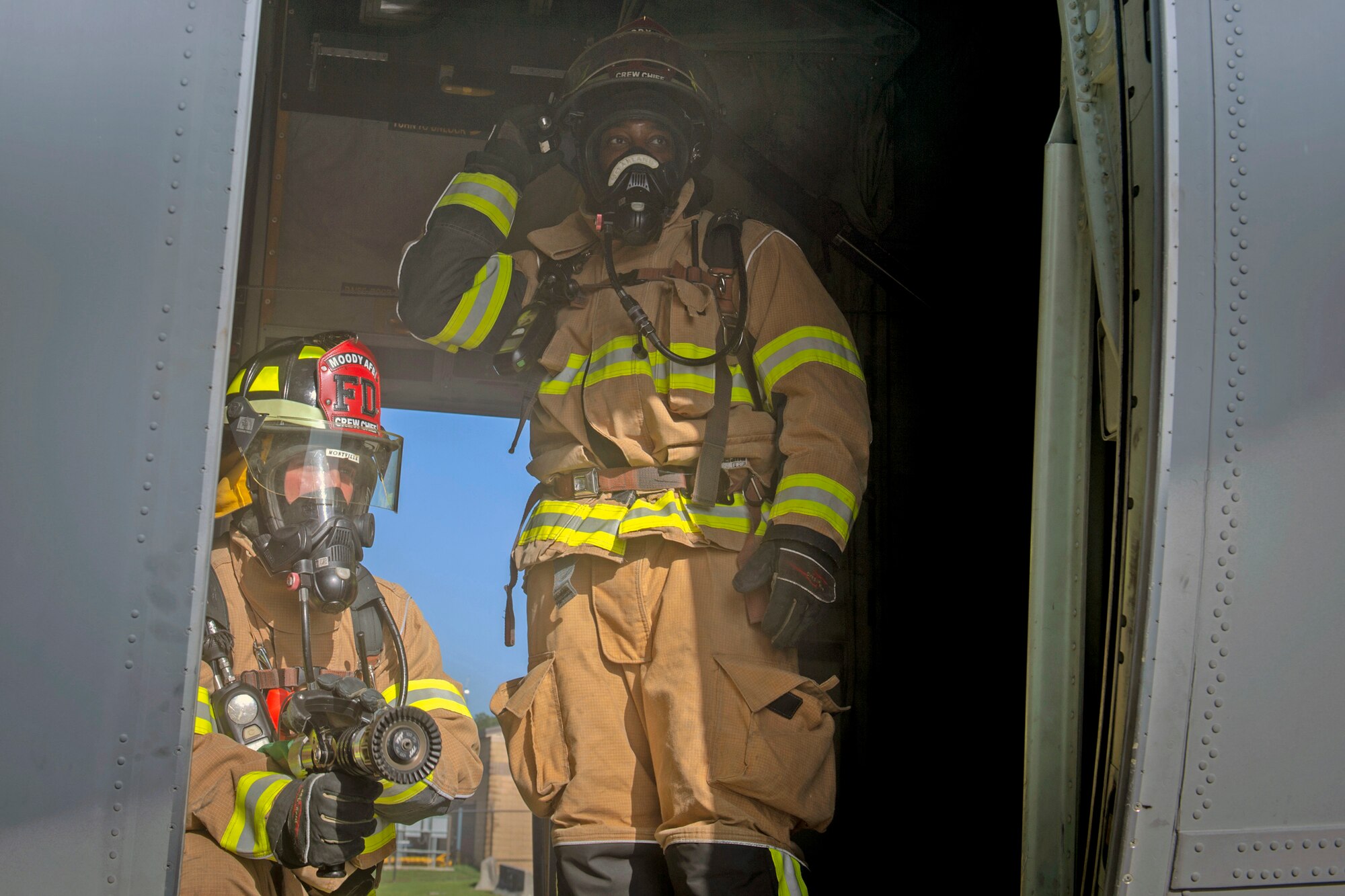 Staff Sgt. Matthew Montville, left, and Staff Sgt. Tyler McFarland, right, both 23d Civil Engineering Squadron firefighter crew chiefs, hold their position during an HC-130J Combat King II egress training, July 11, 2019, on Moody Air Force Base, Ga. The 23d CES conducted the exercise to simulate the rescue of victims from a smoking C-130. The firefighters were tasked with locating and providing ventilation within the aircraft to safely remove the victims. (U.S. Air Force photo by Airman Azaria E. Foster)
