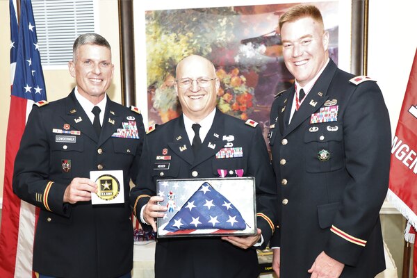 Army Reserve Col. Scott Lowdermilk, U.S. Army Corps of Engineers Transatlantic Division Director of Plans and Operations (left) presents a gift to Sally Heuser, the wife of Army Reserve Col. Todd M. Heuser, who retired July 13, 2019, after a 30-year military career, during a ceremony held in Winchester, Virginia.