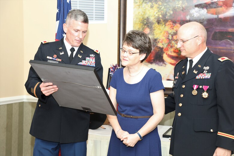 Army Reserve Col. Scott Lowdermilk, U.S. Army Corps of Engineers Transatlantic Division Director of Plans and Operations (left) presents a gift to Sally Heuser, the wife of Army Reserve Col. Todd M. Heuser, who retired July 13, 2019, after a 30-year military career, during a ceremony held in Winchester, Virginia.