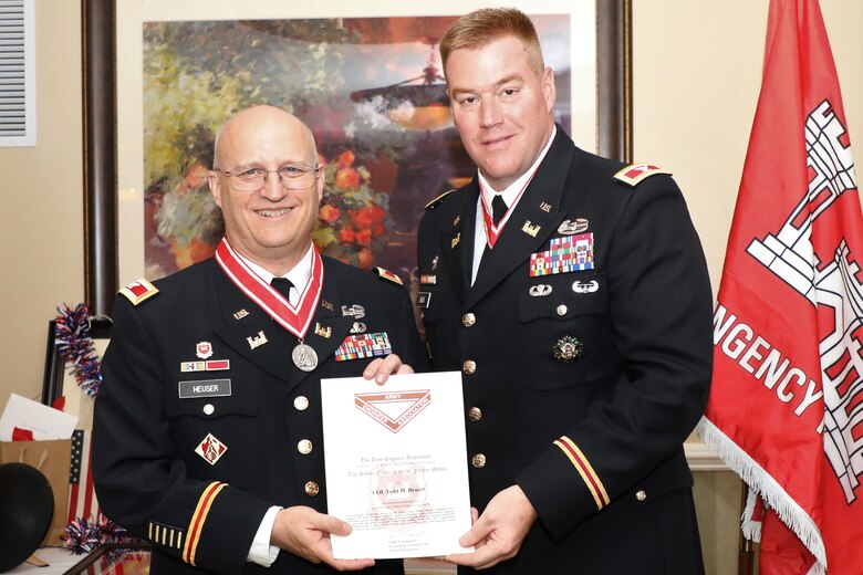 U.S. Army Corps of Engineers Transatlantic Division Commander Col. Chris Beck (right) presents the Army Engineer Association’s Silver Order of the de Fleury Medal and certificate to Army Reserve Col. Todd M. Heuser (center) during Heuser’s retirement ceremony July 13, 2019, in Winchester, Virginia. The de Fleury Medal, was named in honor of François-Louis Teissèdre de Fleury, a French Engineer in the Continental Army, and may only be awarded to an individual who has rendered outstanding and significant support or service to the Engineer Regiment.