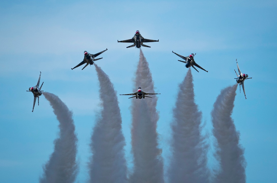 Six aircraft leave thick trails in the the sky.