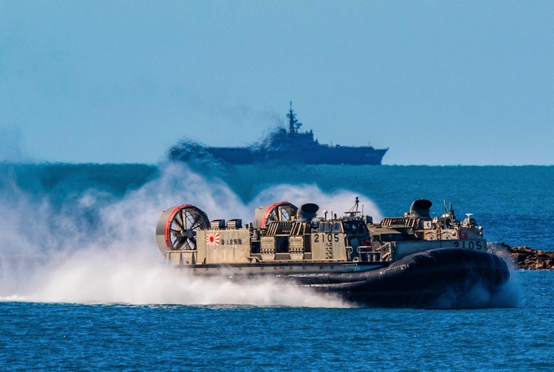 In front of the Japanese Ship Kunisaki, a landing craft, air cushion approaches Langham Beach, Queensland Australia, July 16, during Exercise Talisman Sabre 2019. Talisman Sabre 19 is a bilateral exercise that provides U.S. and Australian forces realistic and relevant training to strengthen regional security, peace and stability.