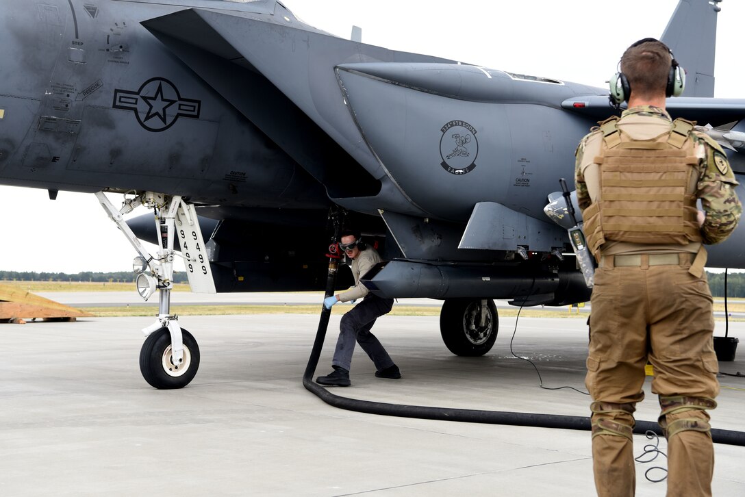 A U.S. Air Force member from the 336th Fighter Squadron, 4th Fighter Wing, Seymour Johnson Air Force Base, N.C, refuels a F-15 Strike Eagle aircraft during Operation Rapid Forge at Powidz Air Base, Poland, July,16, 2019. Operation Rapid Forge is intended to enhance interoperability with NATO allies to improve combined operational capabilities.