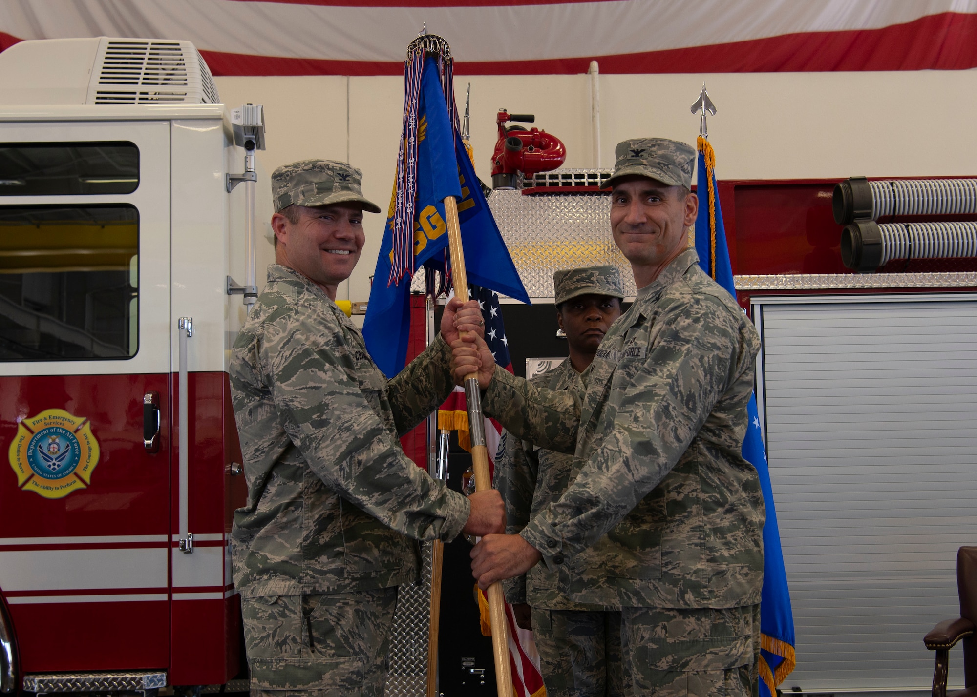 U.S. Air Force Col. Cavan Craddock, commander 99th Air Base Wing, passes the guidon to Col. Anthony Figiera, commander 99 Mission Support Group, during the 99th MSG change of command ceremony on Nellis Air Force Base, Nev., July 7, 2019. The 99th MSG has more than 3,000 military personnel and supports over 479,000 customers annually. (U.S. Air Force photo by SrA Stephanie Gelardo)