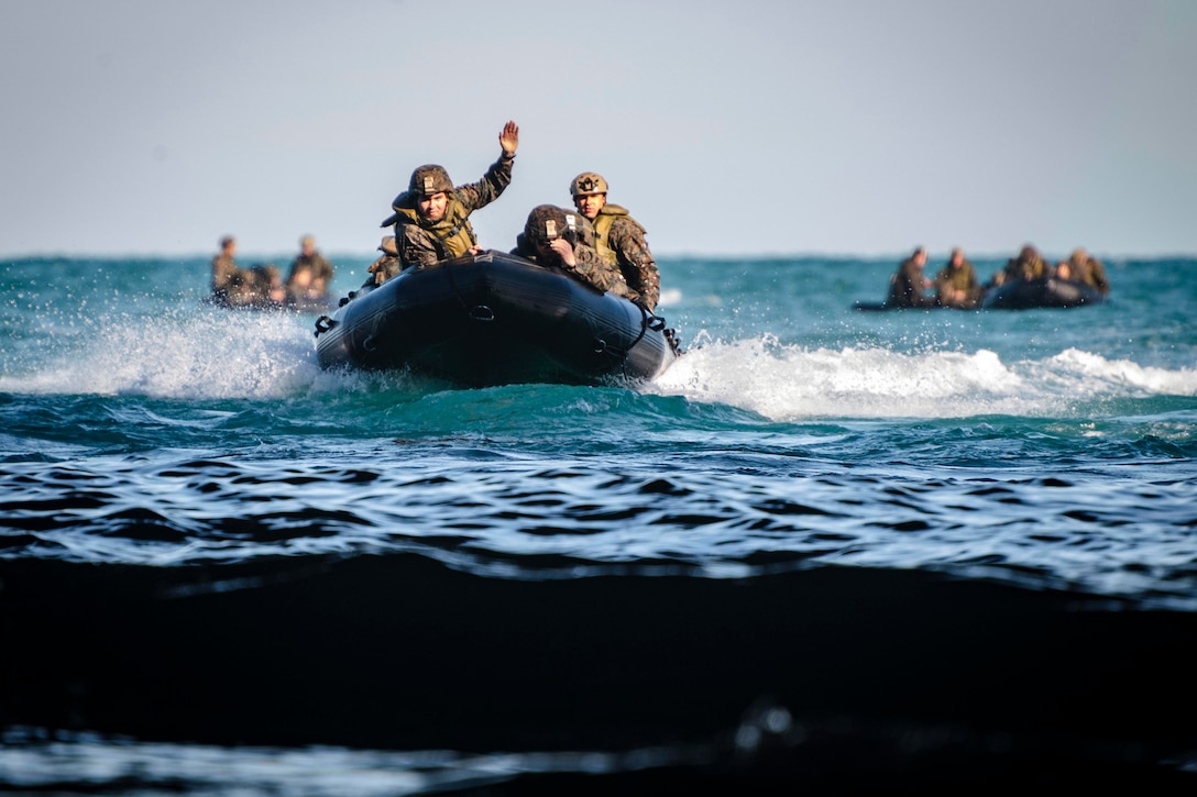 Marines ride in three rubber boats.