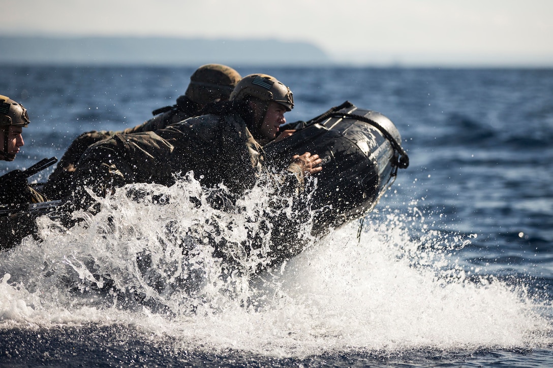 Marines ride in a rubber boat.