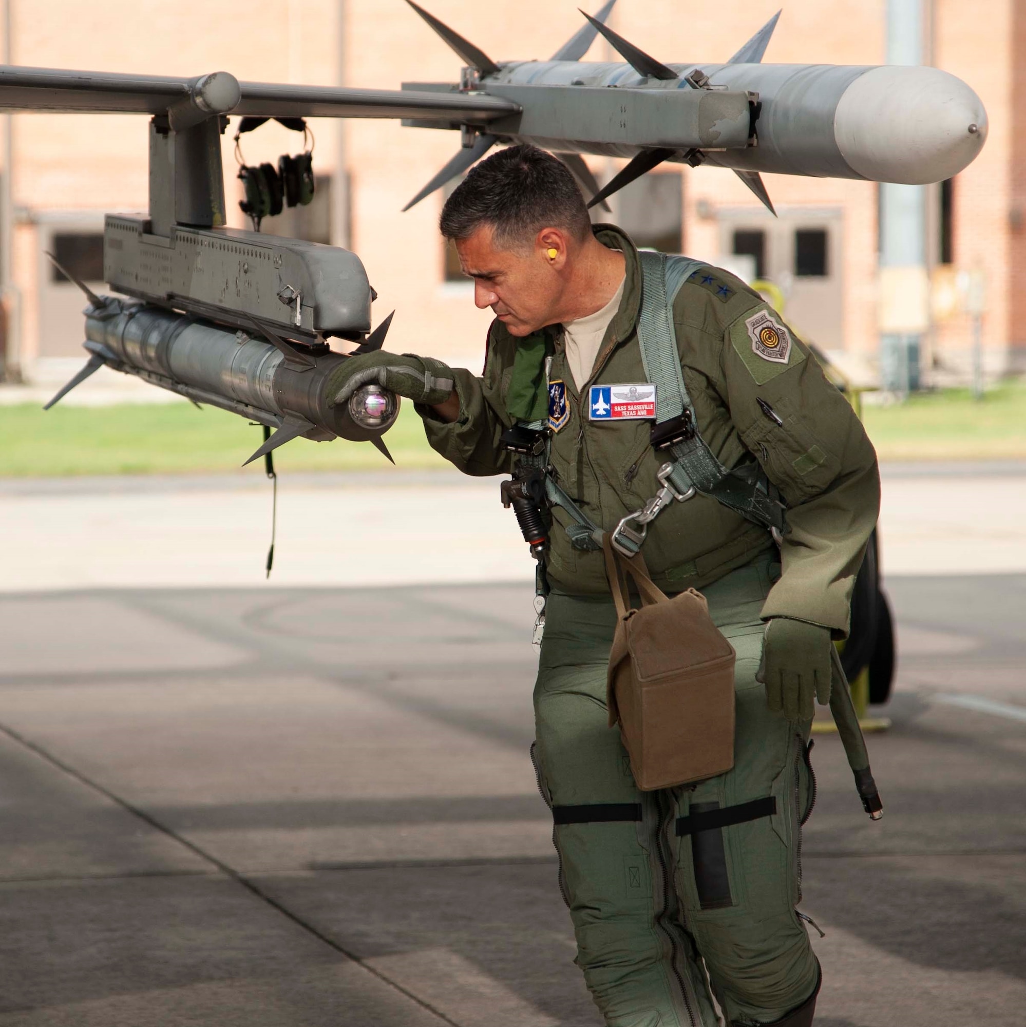Lt. Gen. Marc Sasseville, Continental U.S. NORAD Region-1st Air Force (Air Forces Northern) Commander,inspects an AIM-9X Sidewinder missile on an F-16 Fighting Falcon prior to a flight for the F-16 Senior Officer Course, hosted by the 149th Fighter Wing at Joint Base San Antonio-Lackland. The four-week course, designed to requalify experienced F-16 fighter pilots, focused on advanced handling characteristics, tactical formation and instrument-flying procedures. He also regained his air-air refueling currency during the course along with flying basic fighter maneuvers. He was required to requalify in the fighter jet based on his roles and responsibilities as the CONR-1 AF (AFNORTH) commander.