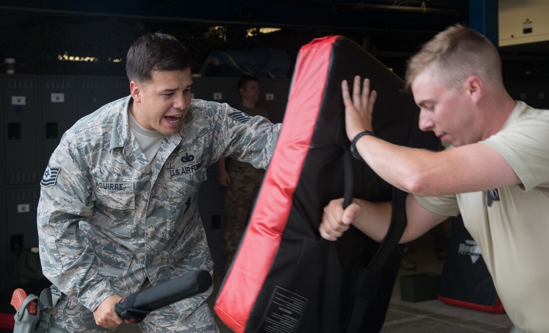 Tech. Sgt. Zeferino Aguirre, 932nd Security Forces Squadron unit training manager , simulates striking an adversary during baton training July 14, 2019, at Scott Air Force Base, Illinois. He is responsible for creating and implementing a training plan such as use of force or baton training. Training involves classroom lecture and hands on skills. (U.S. Air Force photo by Senior Airman Melissa Estevez)
