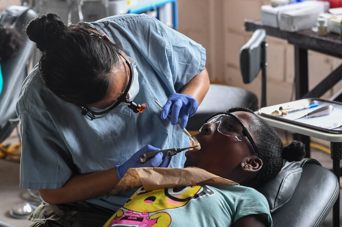 A U.S. Air Force dental technician performs an examination on a Guyanese patient at a Medical Readiness Training Exercise during New Horizons exercise 2019 in Linden, Guyana, July 2, 2019. The New Horizons exercise 2019 provides U.S. military members an opportunity to train for an overseas deployment and the logistical requirements it entails. The exercise promotes bilateral cooperation by providing opportunities for U.S. and partner nation military engineers, medical personnel and support staff to work and train side by side. (U.S. Air Force photo by Senior Airman Derek Seifert)