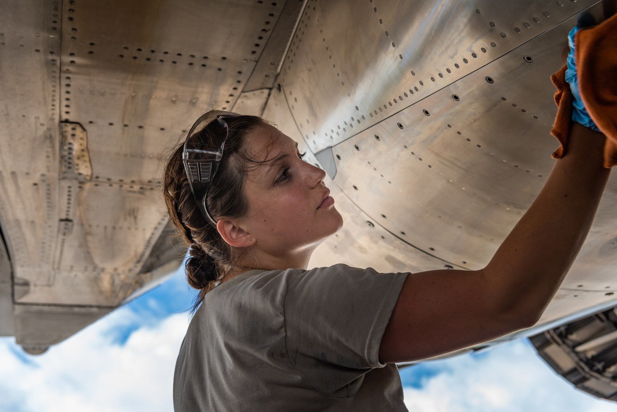 U.S. Air Force Airman 1st Class Hannah Cayton, F-15C Eagle assistant dedicated crew chief assigned to the 44th Aircraft Maintenance Unit, cleans an aircraft during pre-flight inspections July 2, 2019, on Kadena Air Base, Japan. The life of a dedicated crew chief requires non-stop dedication, day and night, to maintain air-to-air combat superiority. (U.S. Air Force photo by Senior Airman Cynthia Belío)