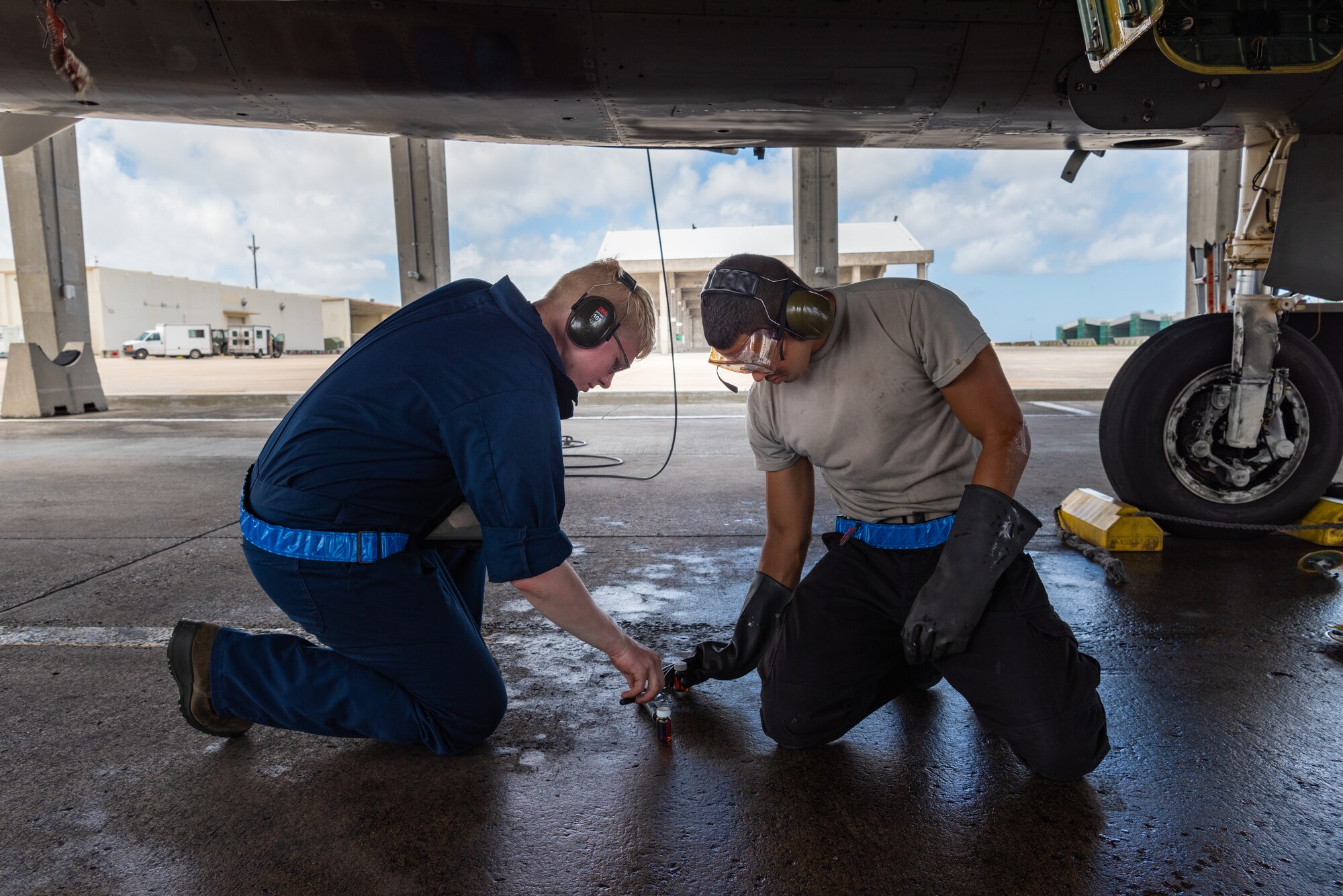 U.S. Air Force Airmen 1st Class Randall Petri, left, and Alfredo Cruz Perez, right, F-15C Eagle assistant dedicated crew chiefs assigned to the 44th Aircraft Maintenance Unit, perform a joint oil analysis program July 2, 2019, on Kadena Air Base, Japan. Members of the 44th AMU are vital to the 18th Wing’s mission, as they spearhead the protection of a free and open Indo-Pacific region by keeping its aircraft in the air. (U.S. Air Force by Senior Airman Cynthia Belío)