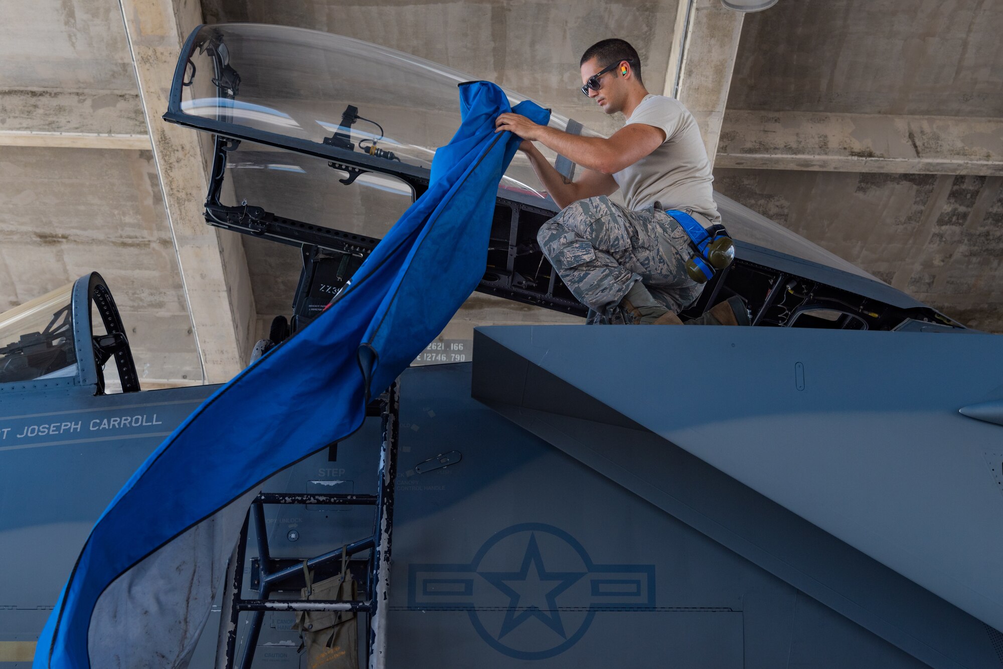 U.S. Air Force Airman 1st Class Christopher Nelson, F-15C Eagle avionics specialist assigned to the 44th Aircraft Maintenance Unit, attaches a protective cover on an aircraft July 2, 2019, on Kadena Air Base, Japan. The life of a dedicated crew chief requires non-stop dedication, day and night, to maintain air-to-air combat superiority. (U.S. Air Force photo by Senior Airman Cynthia Belío)