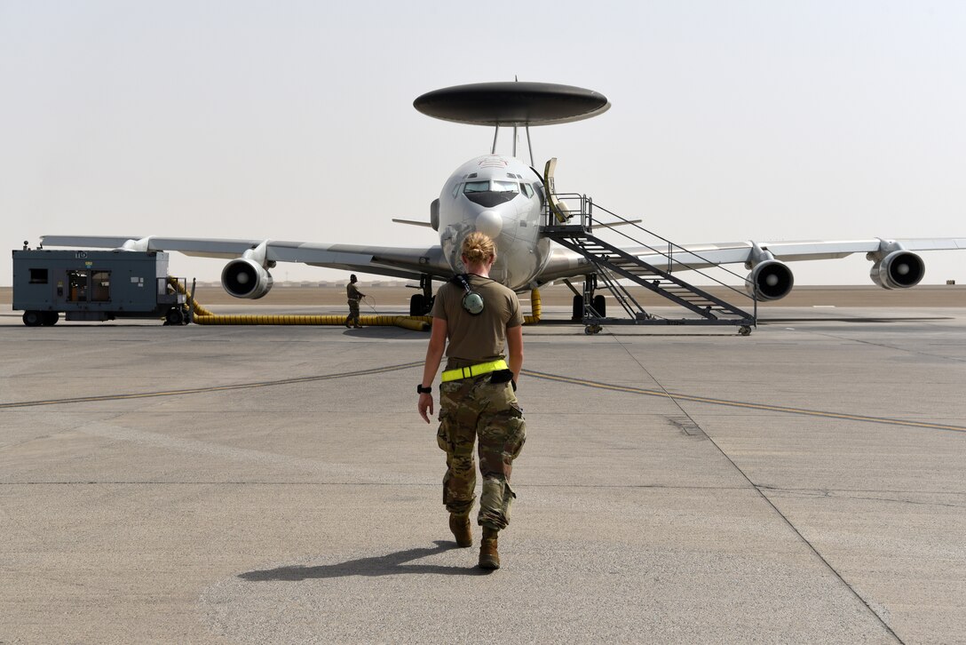 Crew chiefs assigned to the 380th Expeditionary Aircraft Maintenance Squadron perform a foreign object debris walk prior to an E-3 Sentry taxiing for flight on Al Dhafra Air Base, United Arab Emirates, June 26, 2019.
