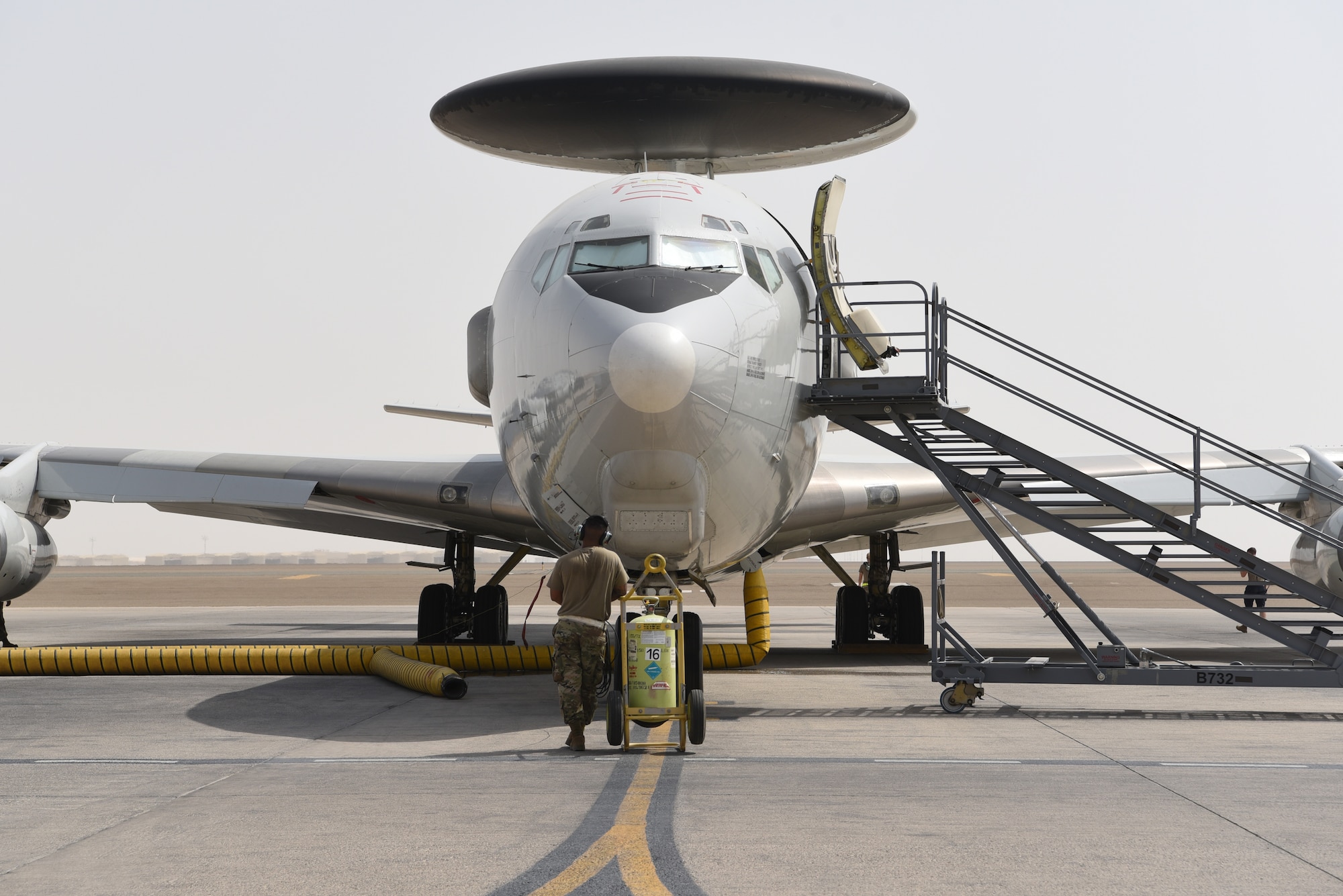 A crew chief assigned to the 380th Expeditionary Aircraft Maintenance Squadron waits in front of the E-3 Sentry on Al Dhafra Air Base, United Arab Emirates, June 26, 2019.