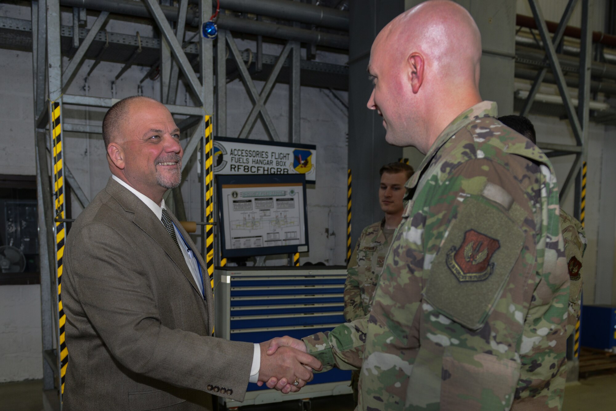 U.S. Air Force Staff Sgt. Zachary Tingen, 86th Maintenance Squadron aircraft fuel systems craftsman, shakes hands with Mr. Scott C. Lockard, 86th Airlift Wing vice director, on Ramstein Air Base, Germany, July 15, 2019. Tingen earned the title of Airlifter of the Week for his leadership and management skills when he stepped up as fuels section chief.