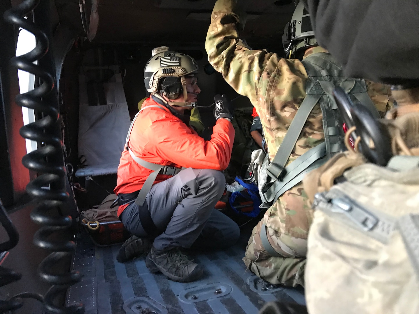 A pararescueman with the Alaska Air National Guard’s 212th Rescue Squadron assesses an injured hiker inside an Army National Guard UH-60 Black Hawk helicopter after two hikers were hoisted off of an Alaskan mountain, July 17, 2019. One of the hikers was injured after falling about 30 feet from a ridge into a saddle, and was unable to walk.