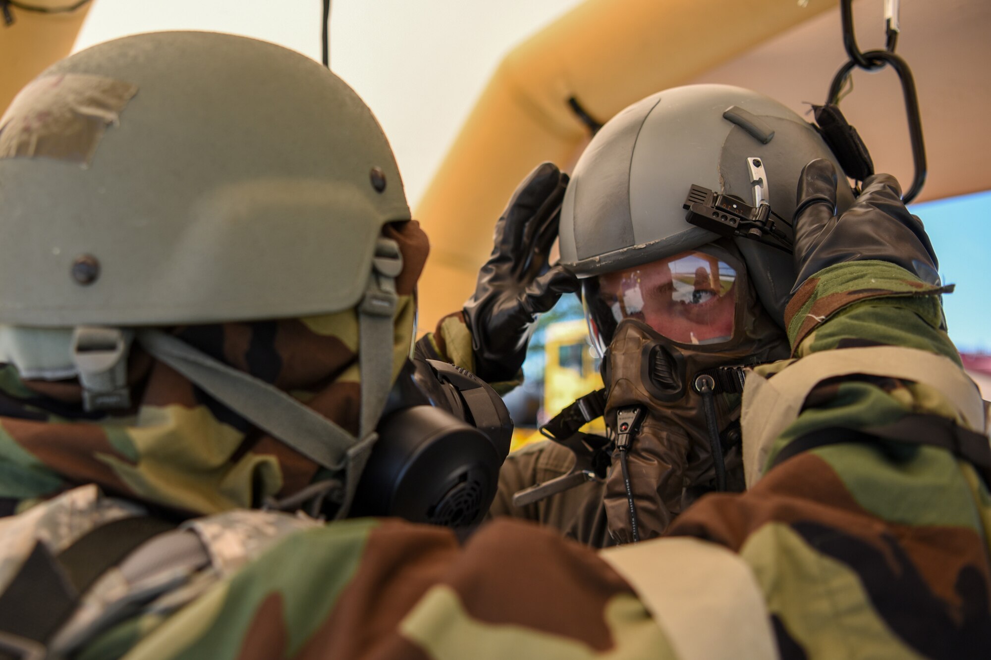 A flight equipment specialist for the Kentucky Air National Guard’s 123rd Airlift Wing assists an aircrew member at a chemical contamination control point during an exercise at the Alpena Combat Readiness Training Center in Alpena, Mich., June 23, 2019. The exercise, called Charred Barrel, tested the wing’s ability to mobilize, fly to a remote site, and operate in a hostile environment. (U.S. Air National Guard photo by Staff Sgt. Joshua Horton)