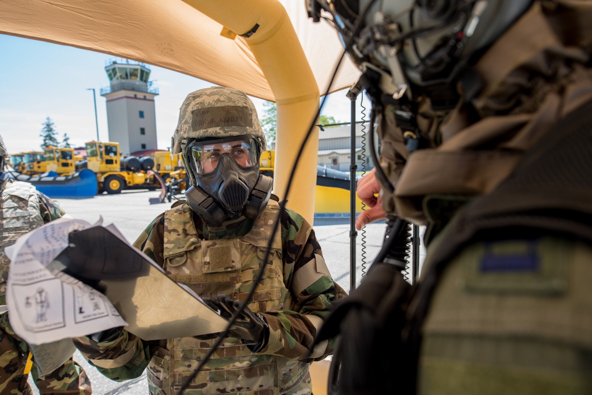 Hannah Nunley (left), flight equipment specialist for the Kentucky Air National Guard’s 123rd Airlift Wing, assists an aircrew member at a chemical contamination control point during an exercise at the Alpena Combat Readiness Training Center in Alpena, Mich., on June 23, 2019. The exercise, called Charred Barrel, tested the wing’s ability to mobilize, fly to a remote site, and operate in a hostile environment. (U.S. Air National Guard photo by Staff Sgt. Joshua Horton)