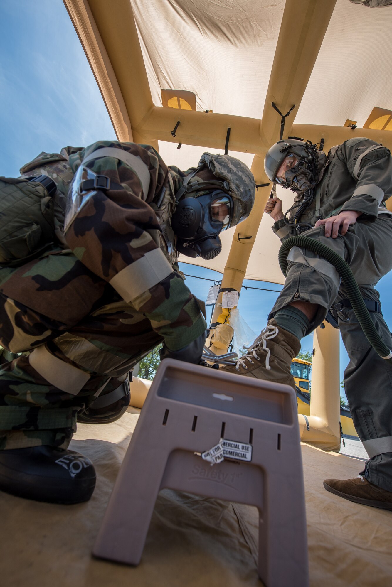 A flight equipment specialist for the Kentucky Air National Guard’s 123rd Airlift Wing assists an aircrew member at a chemical contamination control point during an exercise at the Alpena Combat Readiness Training Center in Alpena, Mich., on June 23, 2019. The exercise, called Charred Barrel, tested the wing’s ability to mobilize, fly to a remote site, and operate in a hostile environment. (U.S. Air National Guard photo by Staff Sgt. Joshua Horton)
