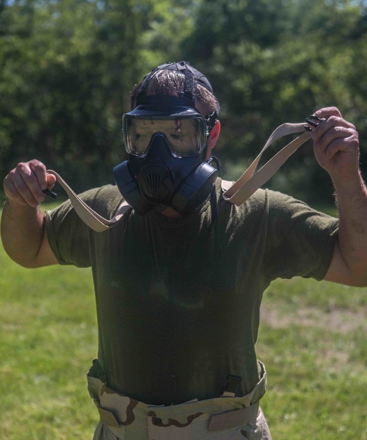 A U.S. Marine with Marine Wing Communications Squadron 48, Marine Air Control Group 48, 4th Marine Aircraft Wing, takes off his Mission Oriented Protective Posture suit at Joliet Army Training Area, Elwood, Ill., July 15, 2019. MWCS-48 is conducting exercises ranging from rifle and pistol qualifications to land navigation in order to meet annual training requirements, as well as increase occupational proficiency. (U.S. Marine Corps photo by Lance Cpl. Preston L. Morris)