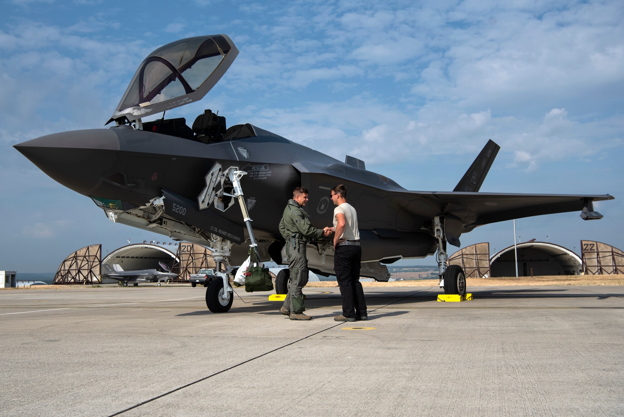 U.S. Air Force Capt. Joseph Walz, 421st Fighter Squadron F-35A Lightning II pilot, shakes hands with Airman 1st Class Cody Albert, 421st FS crew chief, during Operation Rapid Forge at Spangdahlem Air Base, Germany, July 18, 2019. Rapid Forge aircraft are forward deploying to the territory of NATO allies in order to enhance readiness and improve interoperability. Participation in multinational operations enhances the U.S. Air Force's relationship with partner militaries. (U.S. Air Force photo by Airman 1st Class Valerie Seelye)